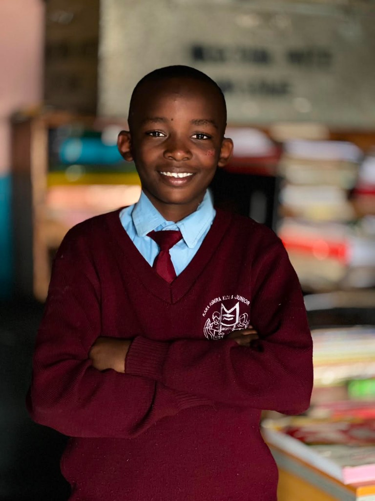 Smiling Elimisha sponsored learner in school uniform